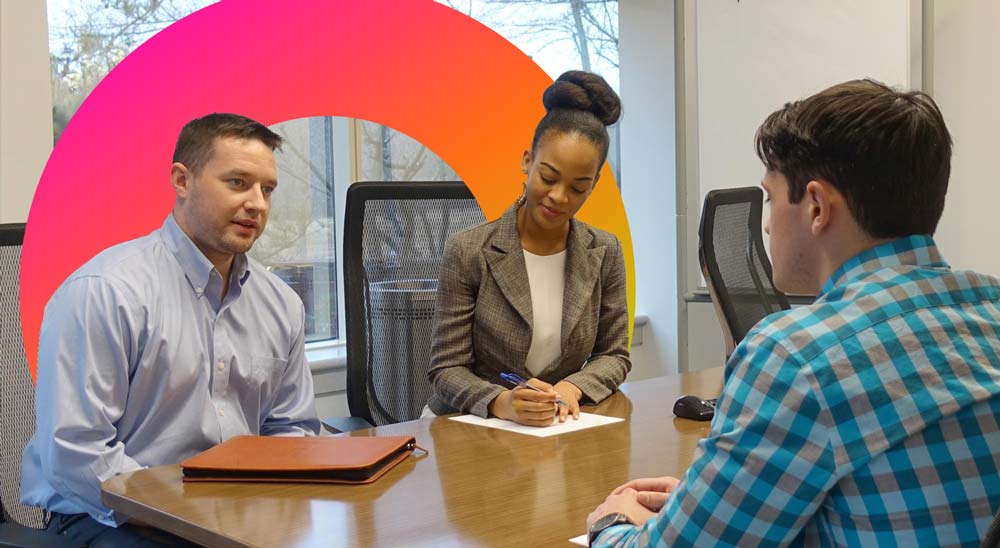 Three people hold a discussion in an office