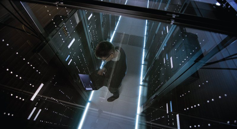 IT working with laptop in data center