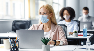 Girl sitting at desk with mask on