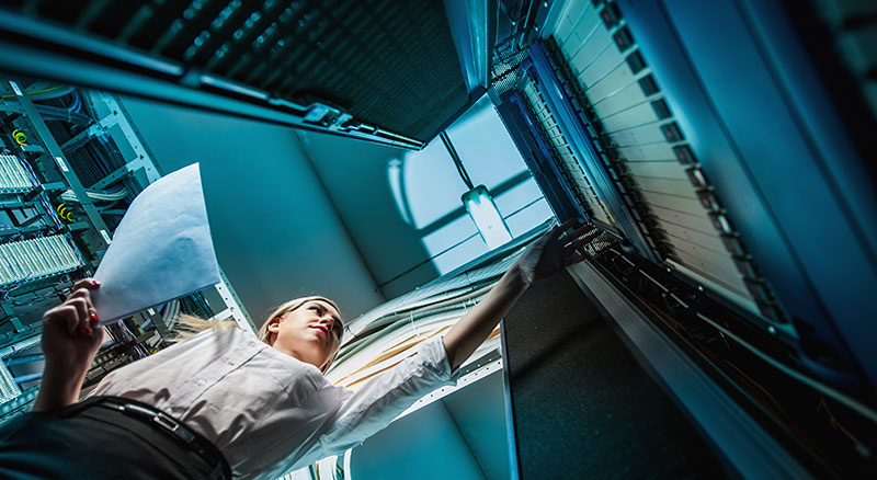 An individual reaches out towards a server rack