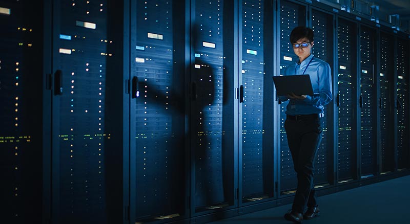 it personel on a laptop in datacenter