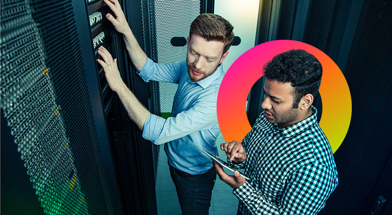 Two men in server room one on a tablet