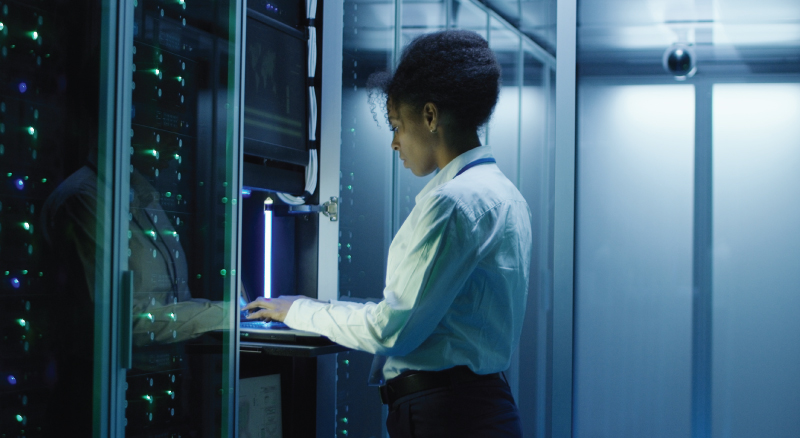 Woman on computer in server room