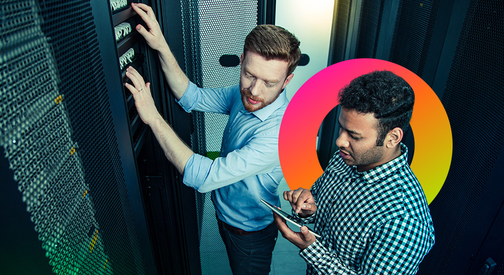 Two men in server room one on a tablet