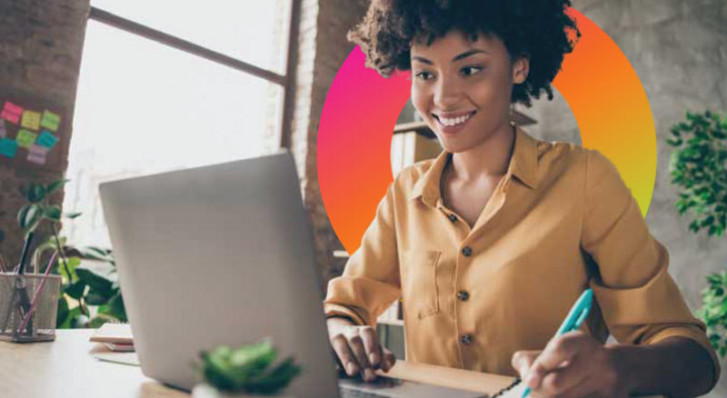 Woman working on computer at desk smiling