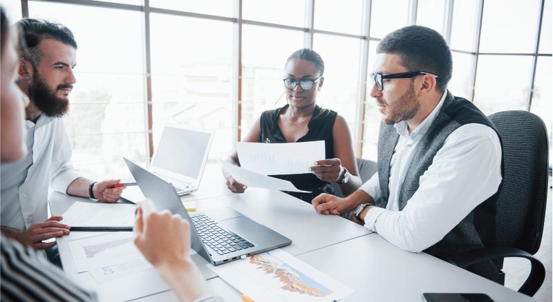 Team of people in a conference room with a laptop