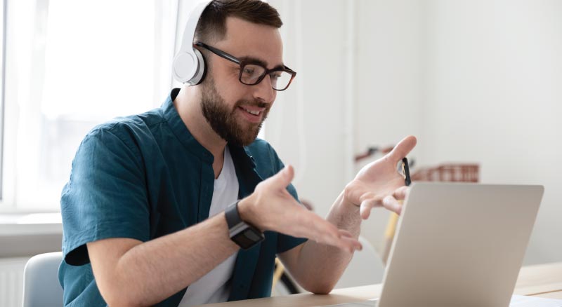 Man with headphones on video chatting on computer