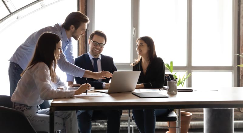 Men and women having a meeting and on the computer