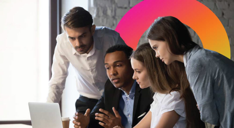 Group of coworkers huddled around computer