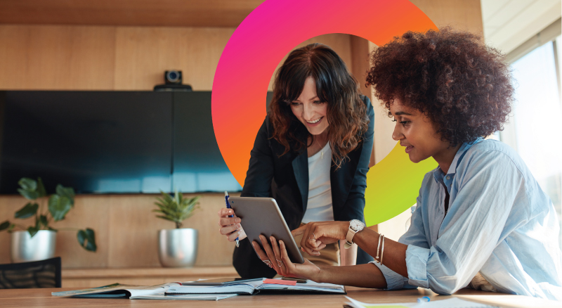 Two women on ipad together in office