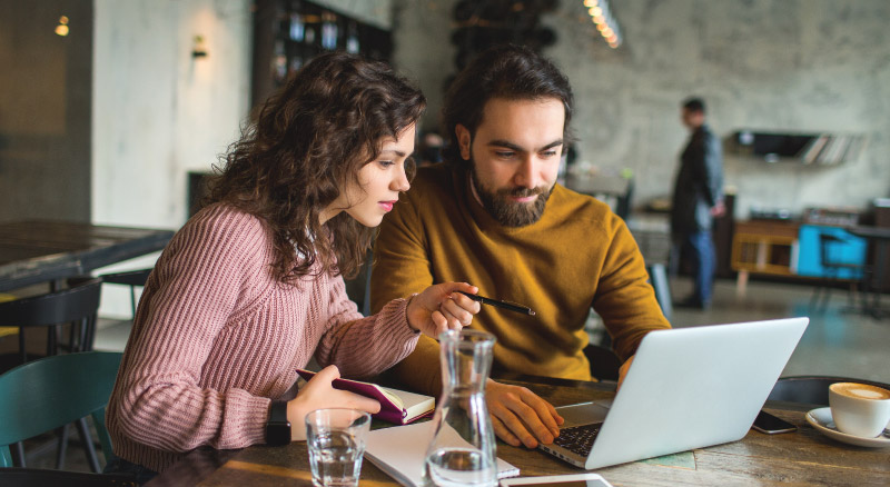 Man and woman on computer workingin coffee shop