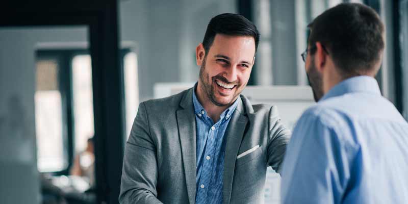 Two professionals are engaged in a conversation in a modern office setting