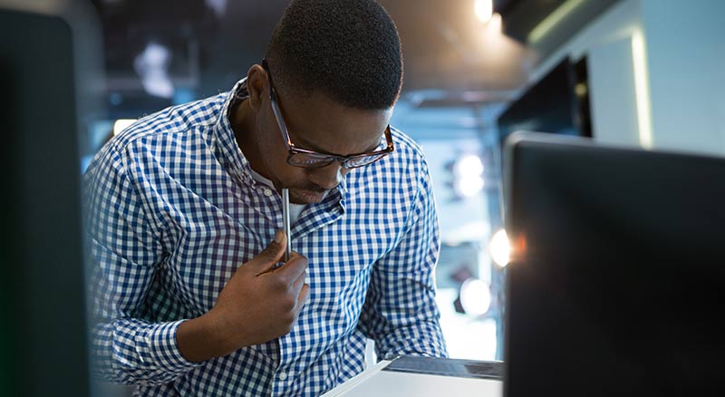 A person in deep thought while holding a digital tablet