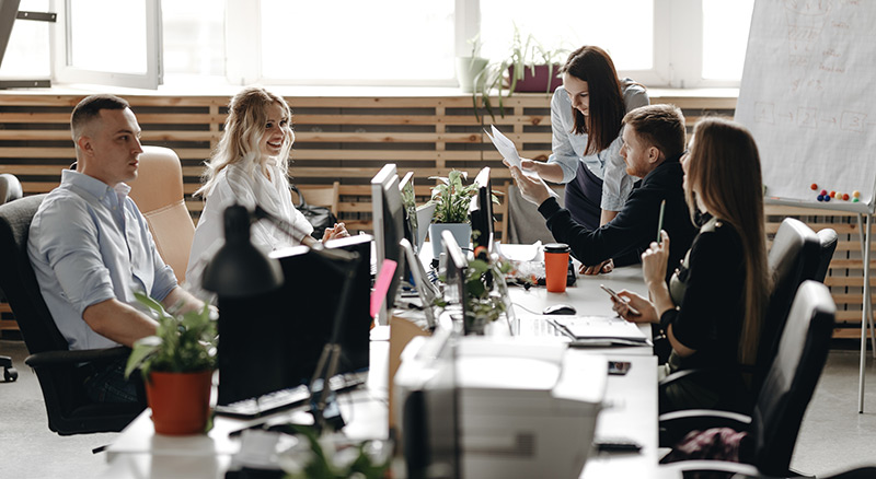 Multiple professional people engaged in conversation sitting at a table