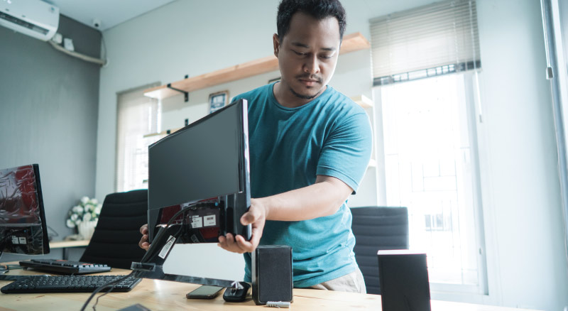 Man setting up computer at desk