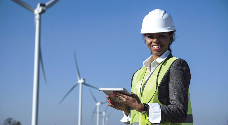 Woman in hard hat holding table outdoors