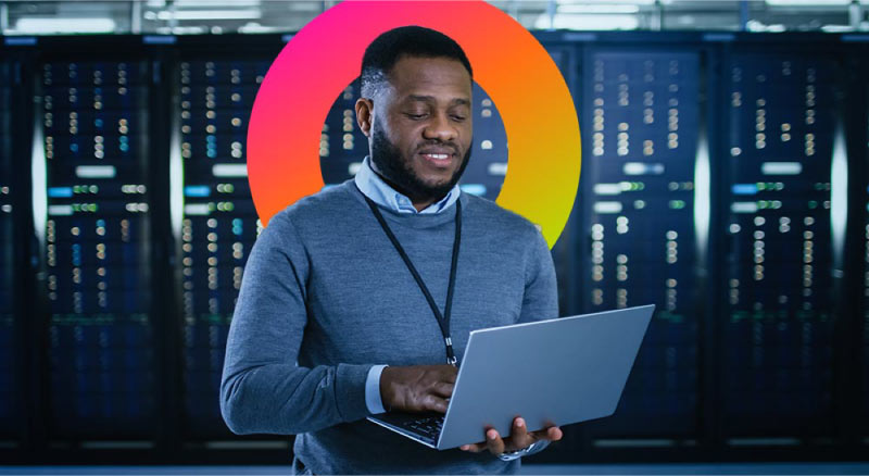 Man working on laptop in data center