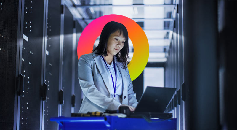 Woman on laptop in data center