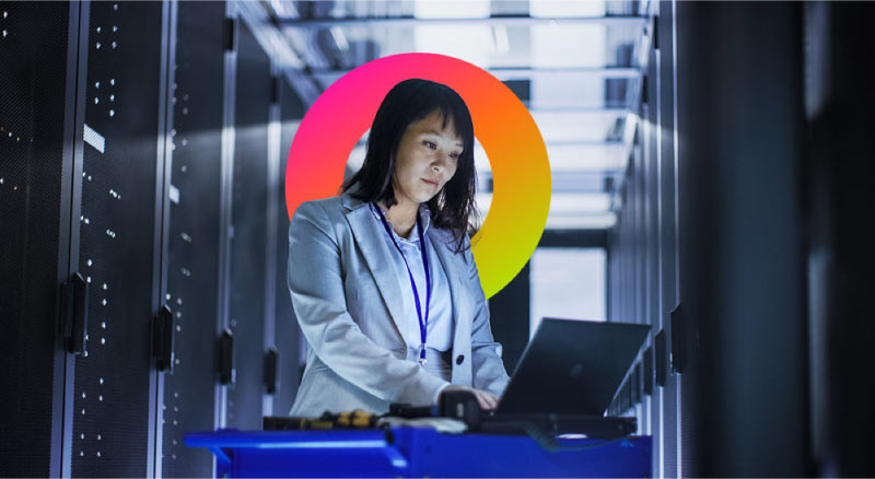 Woman working on laptop in data center