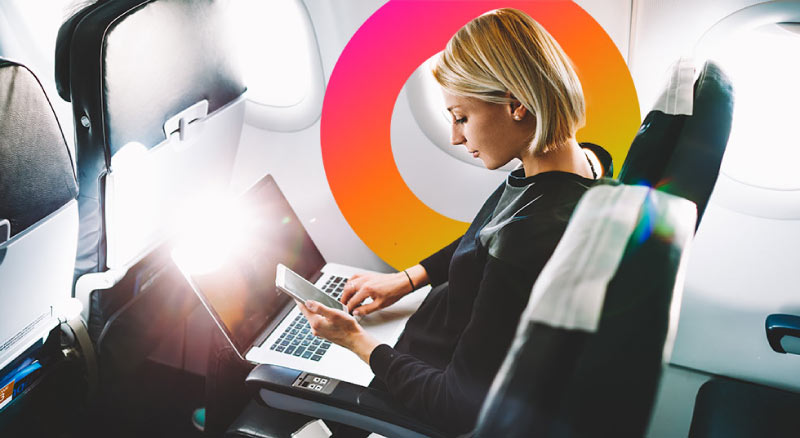 Woman using laptop and cellphone on airplane