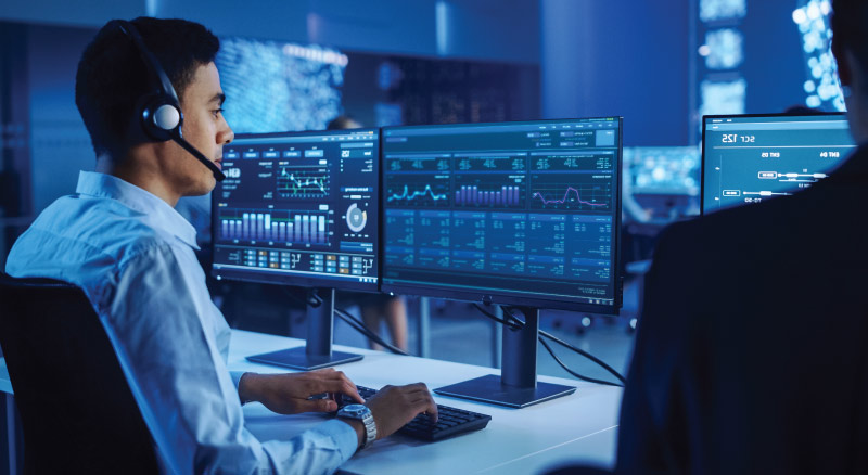 Male wearing a headset on computer in data center