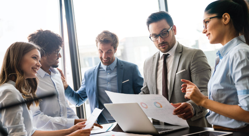 Businessmen and woman meeting looking over graphs
