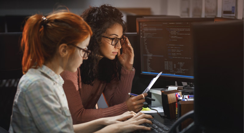 Two female programmers working on project