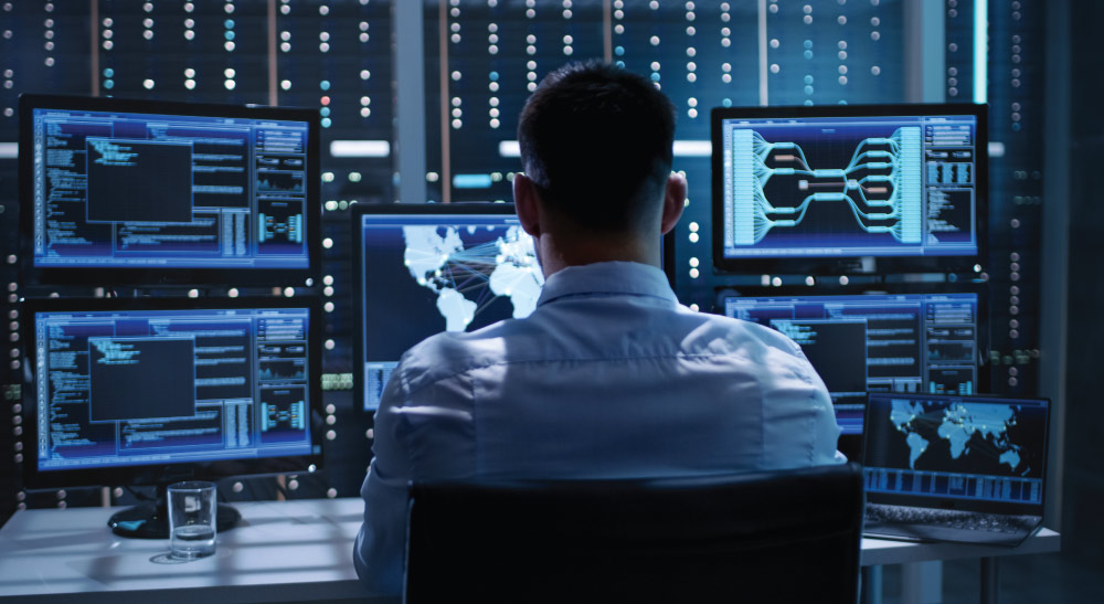 Man in data center on multiple computers