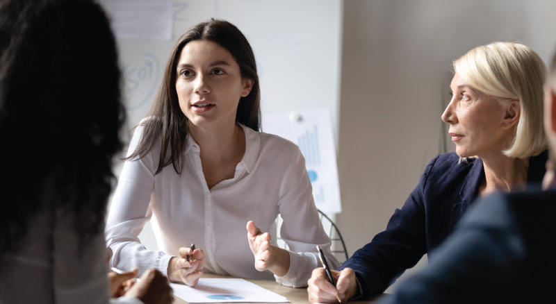 Young businesswoman speaking at corporate meeting