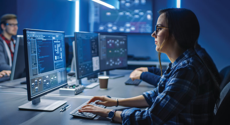Young female programer working on desktop in data center room