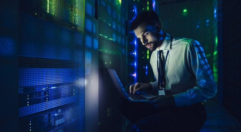 Man on laptop in data center