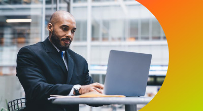An employee in a suit working on a laptop