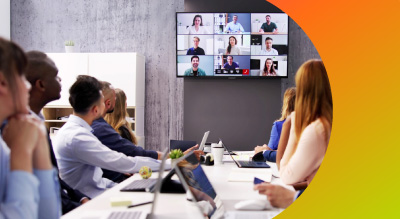 A diverse group of professionals collaborating in a conference room, each using laptops for discussion and presentations