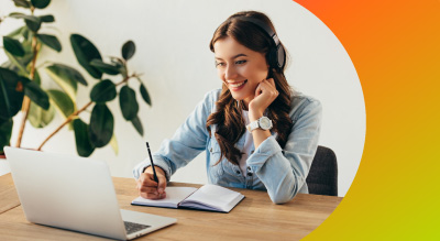A woman wearing headphones is seated at a desk, focused on her laptop, creating a productive work environment.
