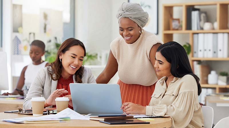 Employees at corporation discussing around a laptop