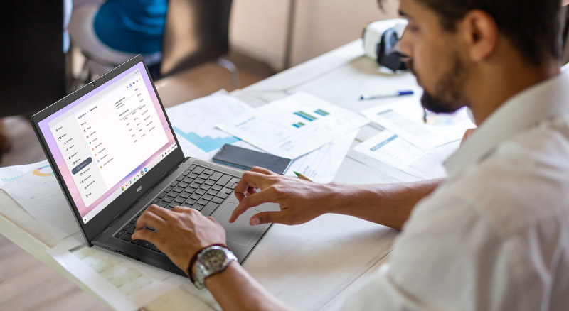 Man sitting at desk typing on acer laptop
