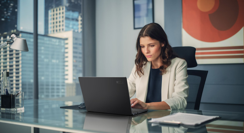 Woman sitting at desk typing on acer laptop
