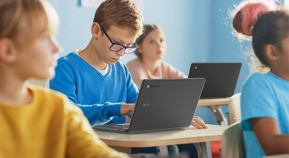 Coworkers looking at two desktop screens