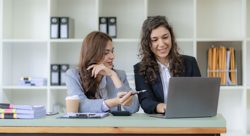 Businesswoman and accountant talking with laptop and tablet