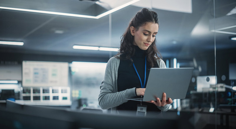 Person in an office holding a laptop