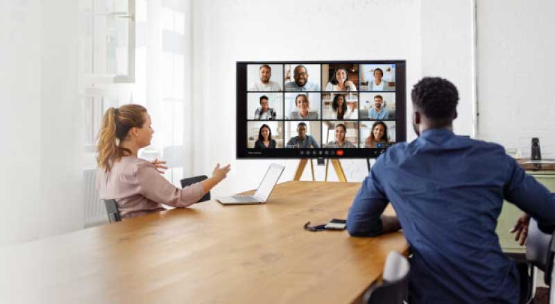 Man and woman in a meeting room on a zoom call