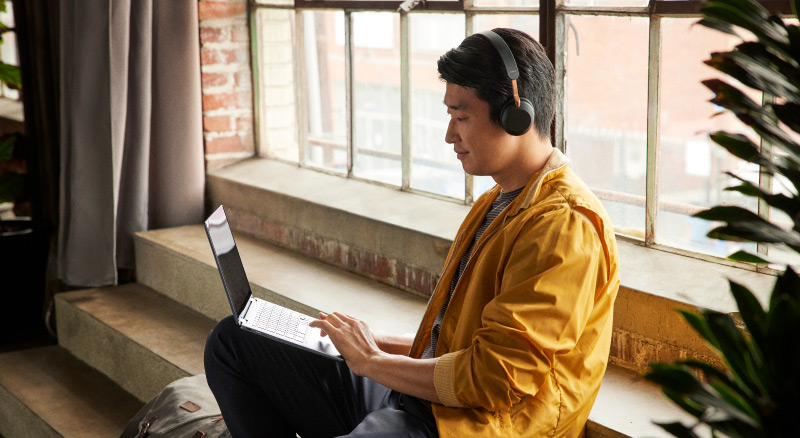 Man working on a laptop with headphones on