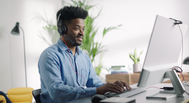 man on computer and headset