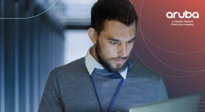 A professional person with their face obscured, holding a laptop, with the Aruba logo and text on the top right corner.