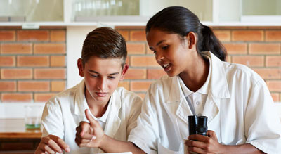 Two people in white lab coats discussing something.