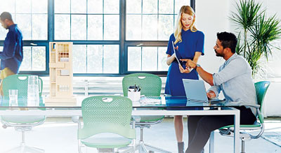 One standing employee shows coworker information on her digital tablet