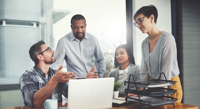 Planning, laptop and coaching with business people in meeting for project management, review or teamwork. Technology, website and training with group of employees in office for collaboration and idea