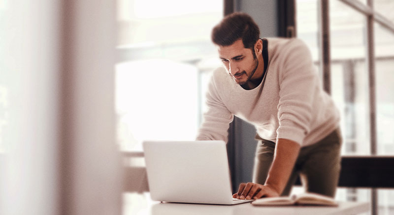 A person working on a laptop in a bright office setting