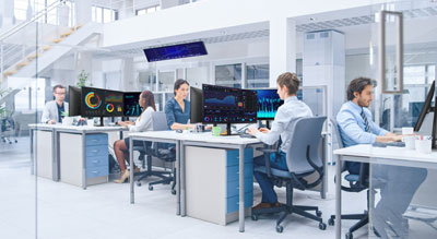 A modern office with professionals working at desks in a bright, airy environment