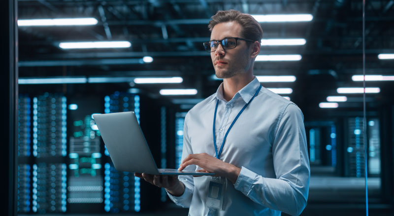 Chief Engineer Stands in the Middle of the Lab and Uses Laptop